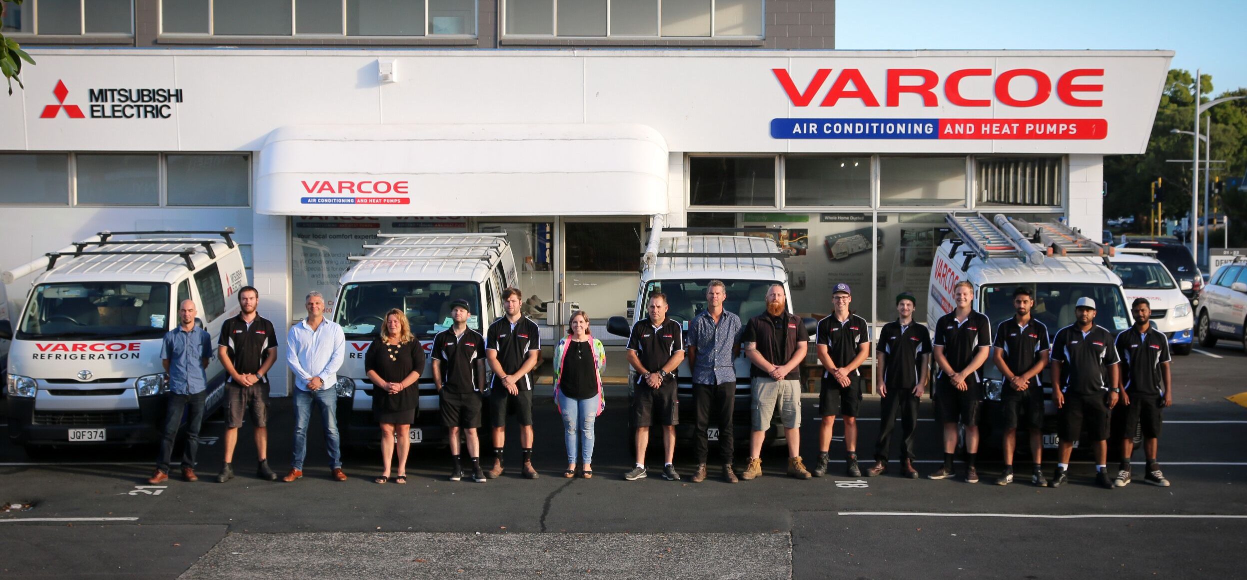Varcoe staff and team memebrs standing otuside of their workplace with varcoe branding